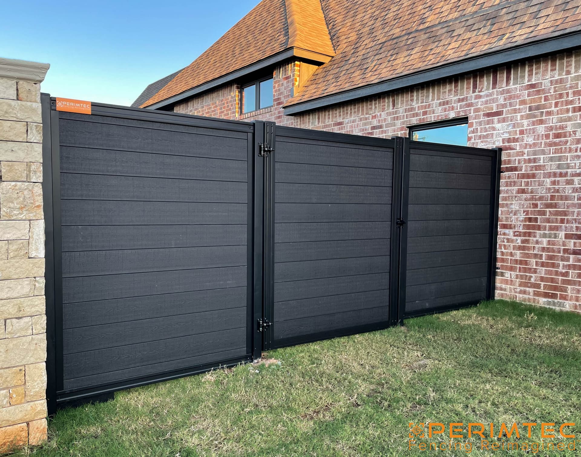 Premium steel-framed gate installation paired with a modern privacy fence system.