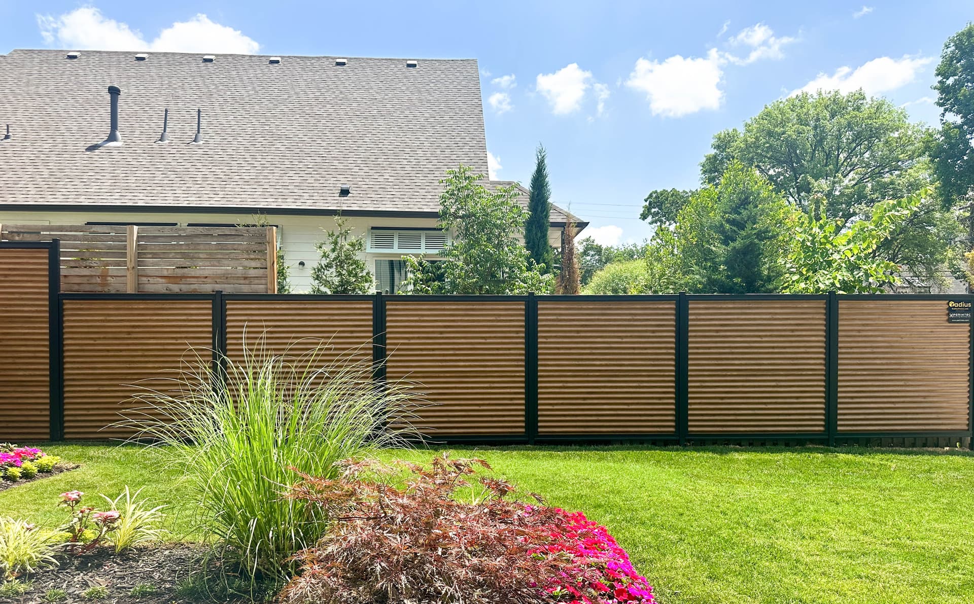 Corrugated metal fence panel in a Perimtec Steel Frame system