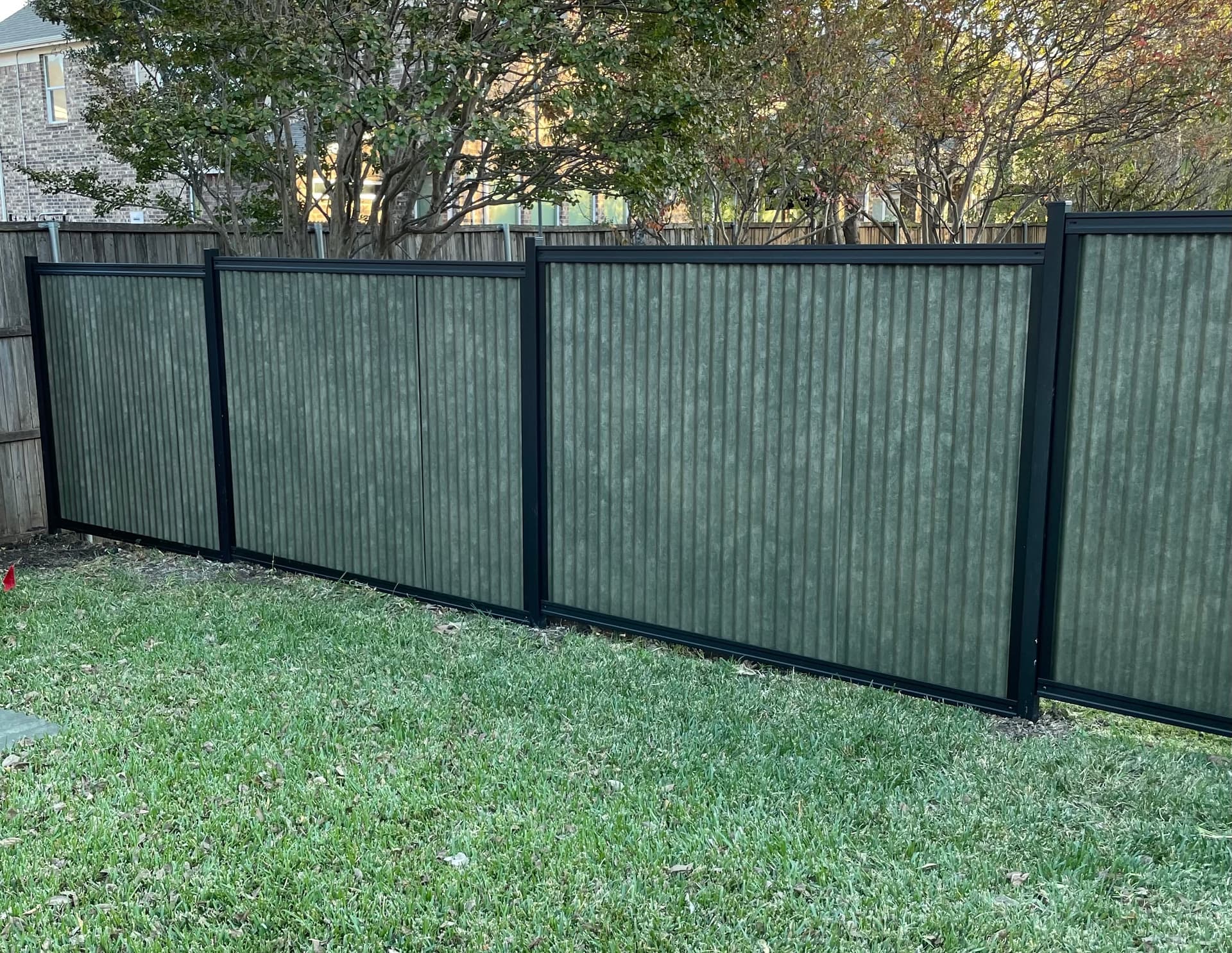 Six foot corrugated metal privacy fence section in a steel frame
