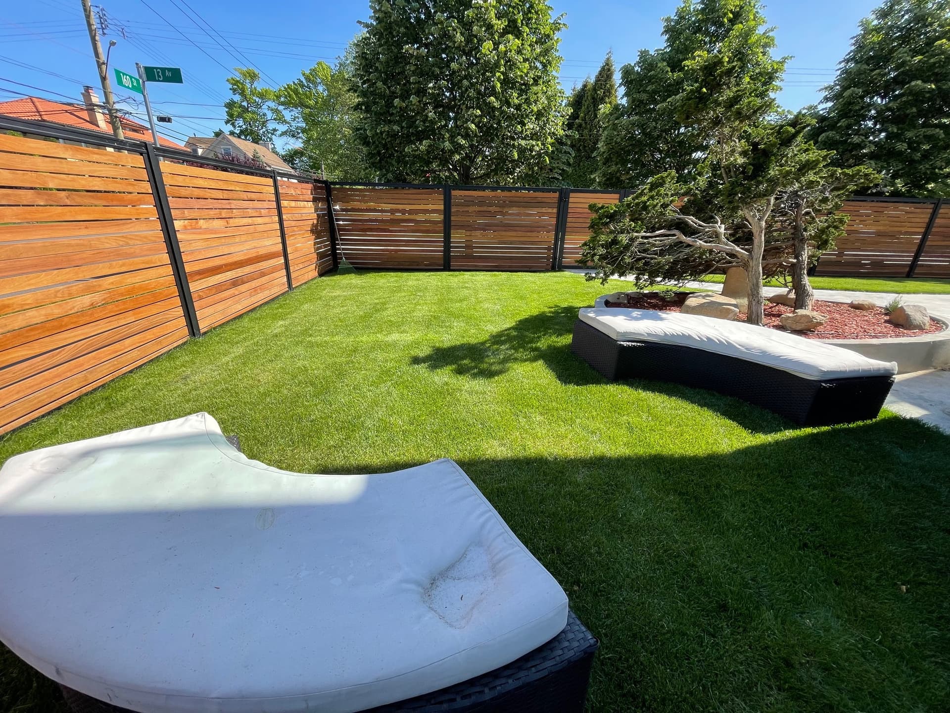 6 foot tall by 6 foot wide Perimtec steel frame fence system in a landscaped yard.