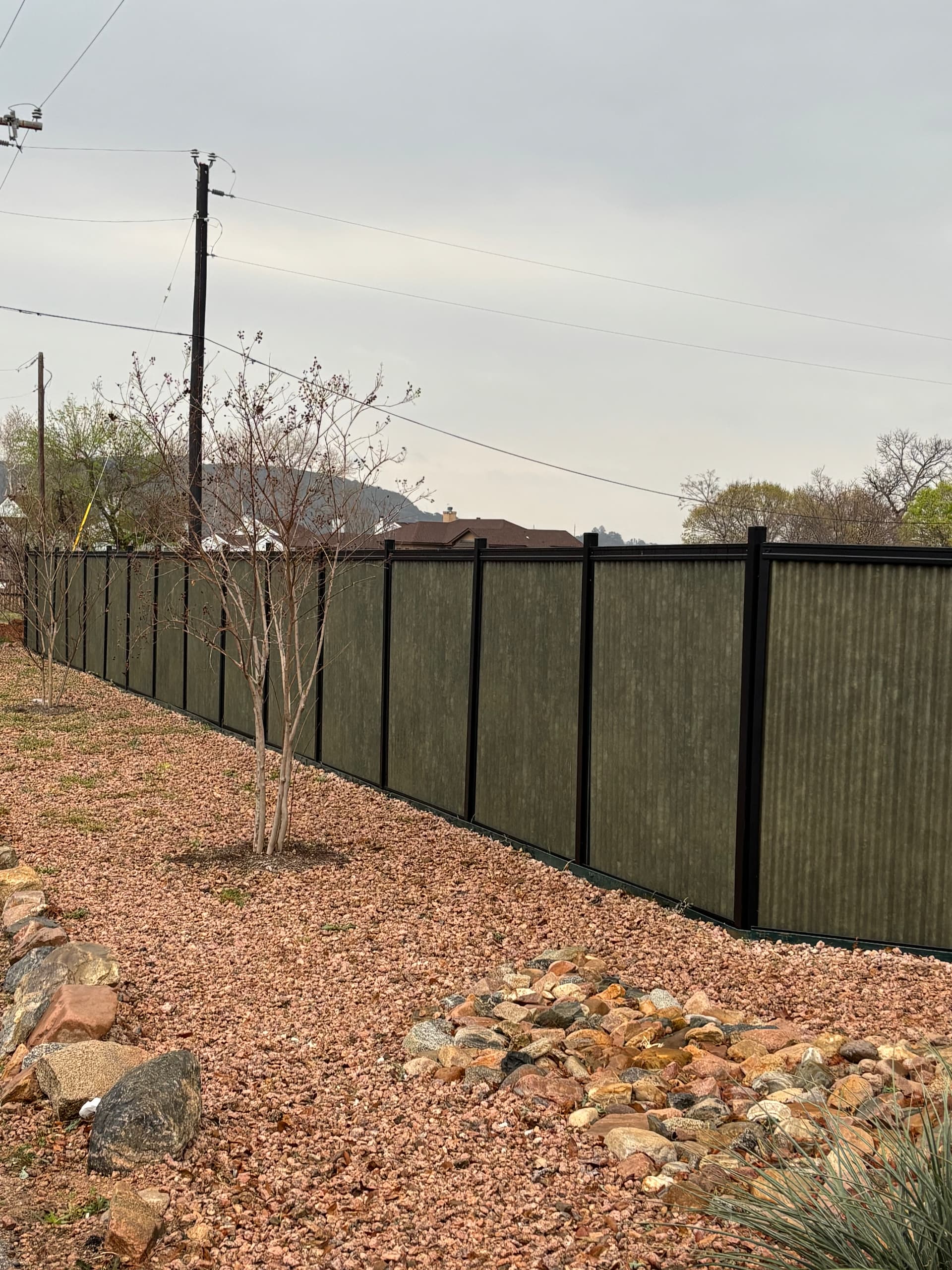 Vertical corrugated metal privacy fence design in a steel frame system