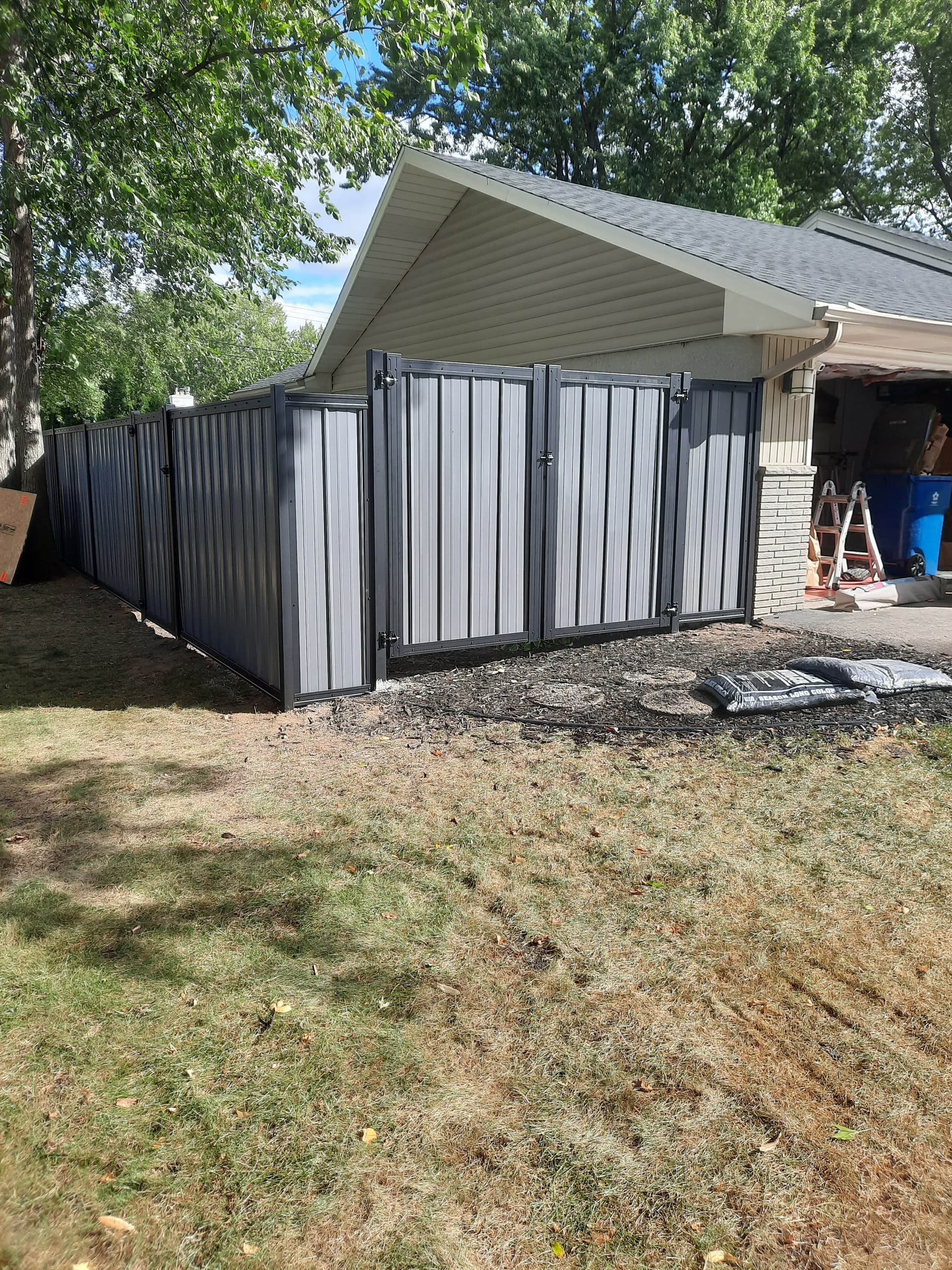 Corrugated metal fence installation showing framed metal privacy fence construction