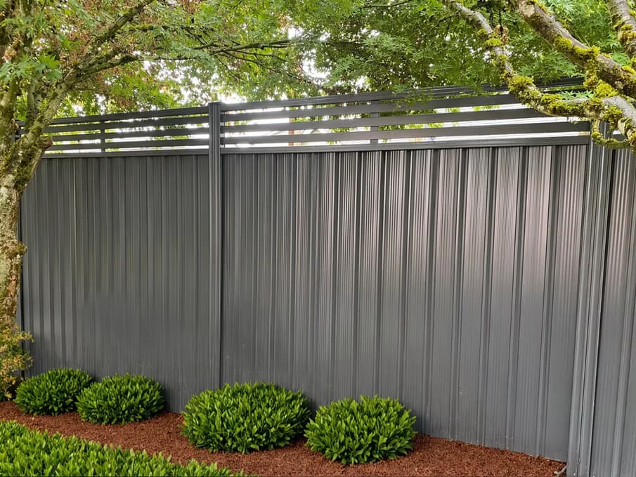 Solid steel privacy fencing run with clean horizontal lines.