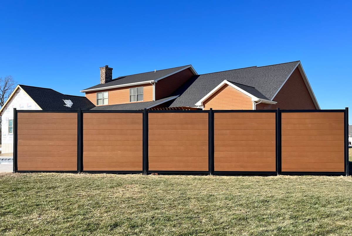 Steel frame fence system with composite infill and modern framing lines.