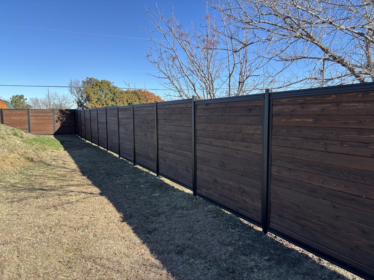 Steel frame fence system with wood infill for a warmer privacy look.