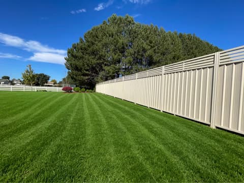 Commercial privacy fence run with durable steel slat construction.